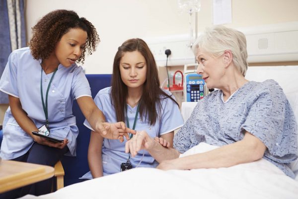 Nurses helping their medication with her care by having a conversation with her