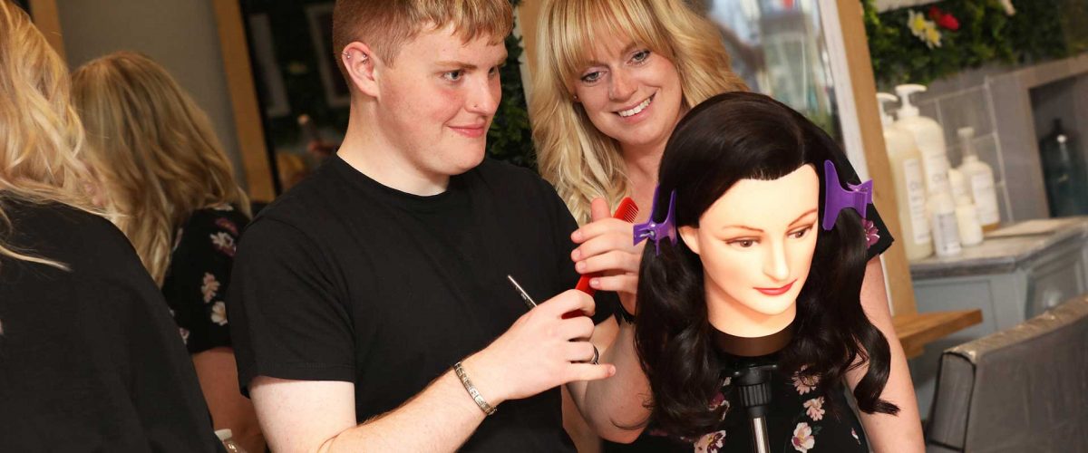 hairdressing traineeship taking place on a hairdressing dummy