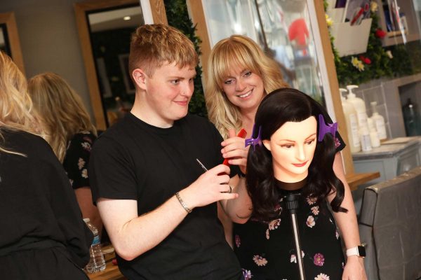 hairdressing traineeship taking place on a hairdressing dummy