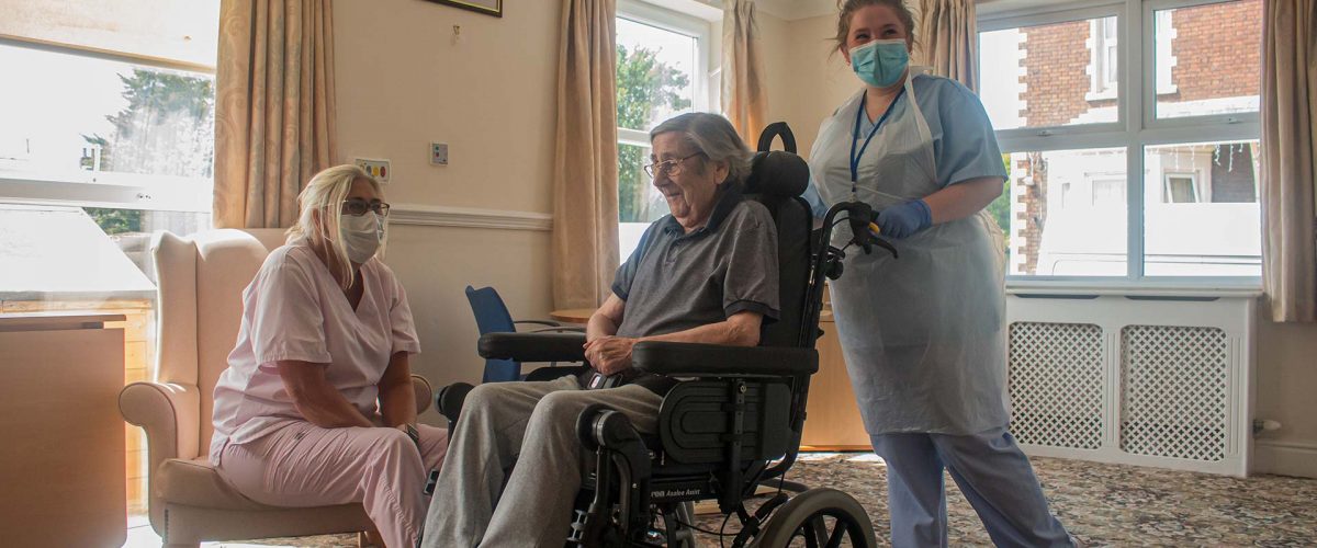 A carer walking with her care patient and fellow carer.